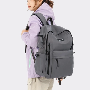 Close-up of waterproof grey nylon backpack featuring multiple functional zipper compartments