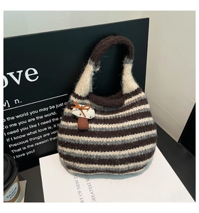 Detail of woven bucket bag with striped pattern and cute mushroom charm with bow