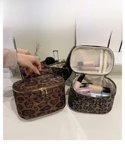 Détail des trousses de toilette léopard avec fermetures éclair doubles et compartiments