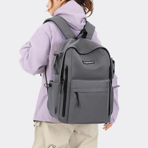 Detail view of large dark grey backpack with multiple zipper pockets and side mesh bag