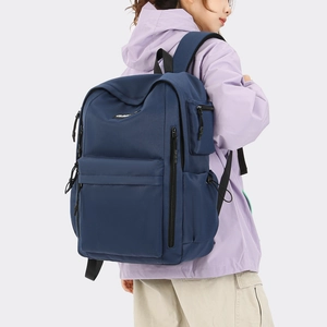 Detail view of navy blue travel backpack with padded straps and multiple zip pockets
