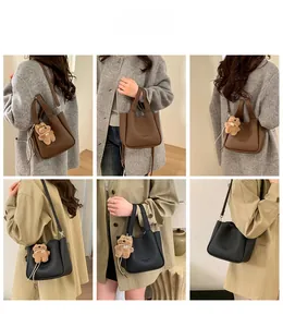 Detail showing simple leather bucket bags in black and brown with cute bear charm detail