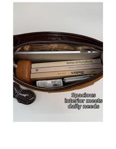 Top view of spacious interior of brown leather tote bag showing laptop and book storage