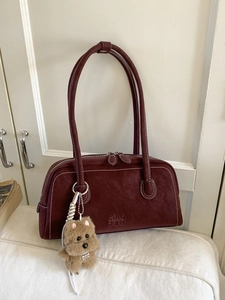 Vintage burgundy bowling shoulder bag with contrast stitching and plush puppy pendant