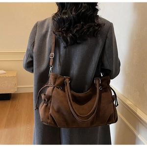Detalle del bolso tote marrón oscuro mate con cordones laterales y asas resistentes