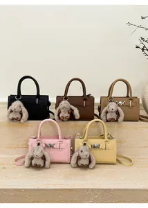 Detail of vintage crossbody bags in five colors with cute plush bunny pendants
