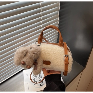 Detail der Plüschtasche aus Lammwollimitat mit Lederriemen und Hundeanhänger