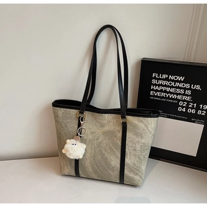 Detail of grey marble texture tote bag with plush sheep charm and gold text