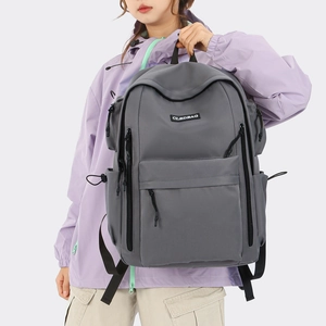 Macro shot of grey multi-compartment travel backpack with front zipper and top handle