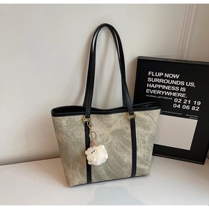 Close-up of marble texture tote bag with golden hardware and plush lamb charm