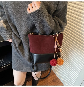 Detail of burgundy suede and black leather patchwork tote with tassel bag charm