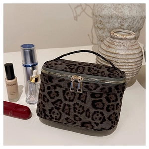 Détail du sac à maquillage imprimé léopard avec double fermeture éclair dorée