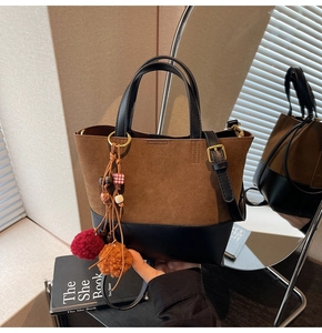 Close-up of retro bucket bag featuring brown suede patchwork and colorful tassel detail