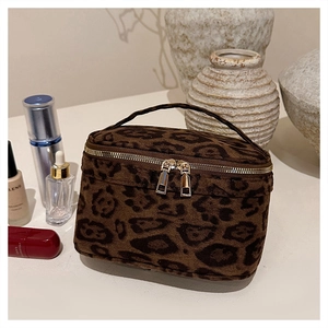 Détail de la trousse de toilette léopard avec texture peluche et zips métalliques dorés