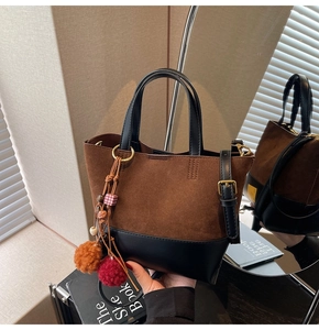 Detail of vintage patchwork tote with suede texture and ethnic tassel charm
