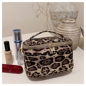 Détail de la trousse de toilette léopard avec poignée et double zip doré brillant