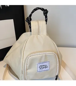Detail of off-white checkered canvas backpack with rope handle and zipper pocket