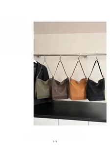 Close-up of retro leather shoulder bags in four colors hanging on a display rack