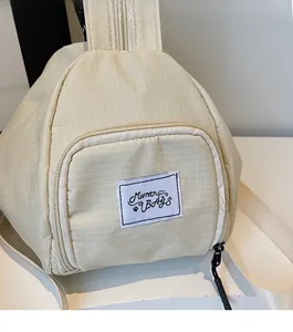 Detail of beige plaid triangle bag with zipper pocket and Muran BAGS woven label