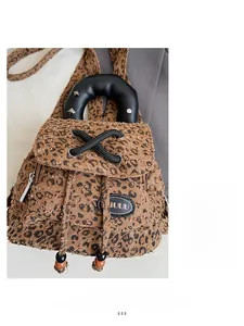 Detail of leopard print backpack with rivet handle and wooden bead drawstring