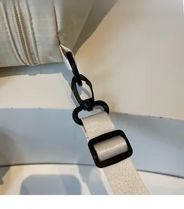 Detail of durable detachable swivel hook and D-ring on beige canvas backpack strap