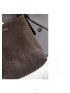 Detail of dark brown matte leather texture and metallic logo on a vintage bucket bag