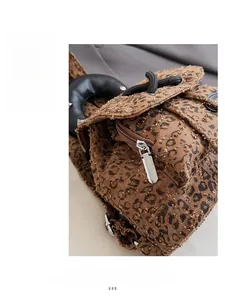 Detail of the smooth silver metal zipper and leopard print canvas texture on the backpack