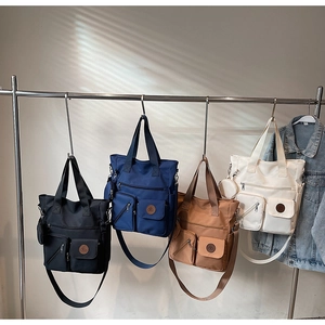 Four versatile canvas tote bags in black, navy, brown, and beige with multi-pocket detail