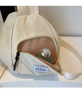Front zipper pocket of cream checkered canvas bag showing storage space for perfume