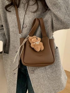 Vintage dark brown pebble leather bucket bag with a cute teddy bear charm on model