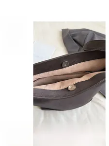 Detail of magnetic buckle closure and litchi texture leather on shoulder tote bag