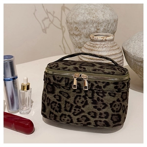 Détail de trousse de maquillage léopard avec fermetures dorées et poignée de transport