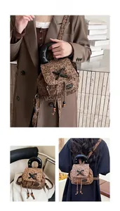 Detail of leopard print mini backpack showing black rivet handle and drawstring flap closure
