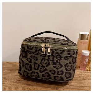Détail de la trousse de toilette léopard en velours avec fermetures éclair dorées