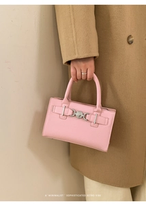Detail of light pink leather handbag with silver heart buckle and textured finish