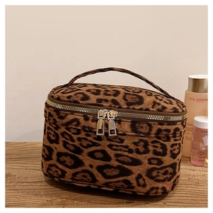 Détail de la trousse de toilette léopard avec doubles fermetures éclair dorées