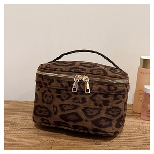 Détail de la trousse à maquillage léopard avec texture peluche et zips dorés doubles