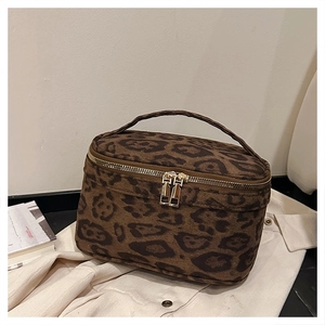 Détail d'une trousse à maquillage léopard avec fermetures éclair dorées