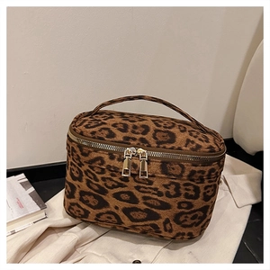 Détail de la trousse de toilette léopard avec doubles zips dorés et poignée renforcée