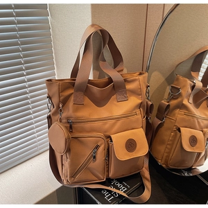 Caramel brown tote bag detail showing large capacity compartments and detachable round purse