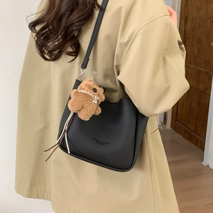 Sac seau noir à motif litchi avec un adorable pendentif porte-clés en forme d'ours brun