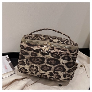 Détail de la trousse de toilette léopard avec fermetures éclair dorées et poignée