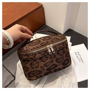 Détail de la trousse de toilette léopard avec texture en daim et double zip métallique
