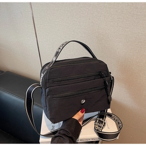 Detailed view of high-density nylon messenger bag with multiple zipper compartments