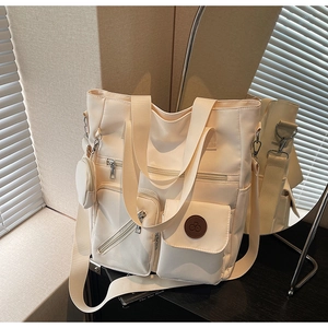 Detail of off-white nylon tote bag with multiple pockets, shoulder strap and coin purse
