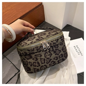 Vue détaillée d'une trousse de maquillage léopard avec double fermeture éclair dorée