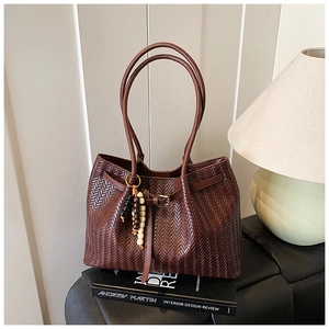 Détail du sac cabas plissé marron foncé avec accessoire de charme en perles de bois