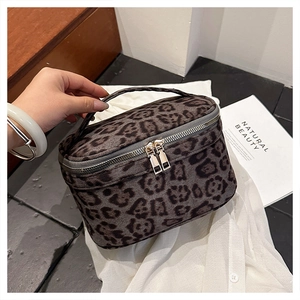 Détail de la trousse de toilette léopard avec poignée supérieure et double zip doré