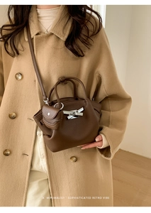 Brown lychee leather bucket bag detail with silver turn-lock and mini coin purse