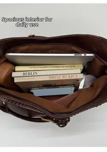 Spacious interior of dark brown soft leather tote bag showing laptop and daily essentials